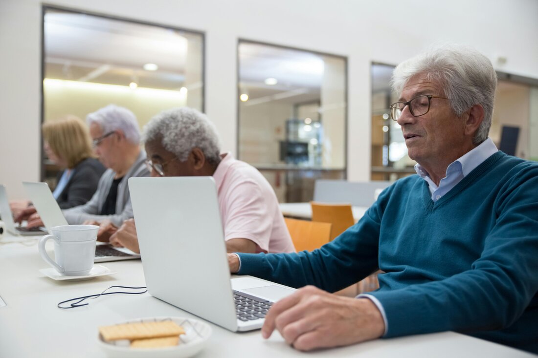 Personne aidant un sénior à utiliser une tablette